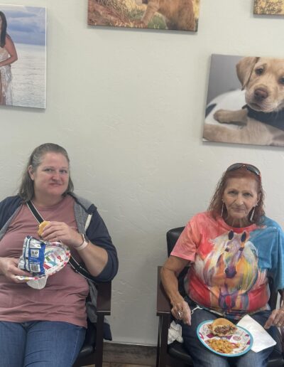 Party goers sitting in the clinic eating snacks.